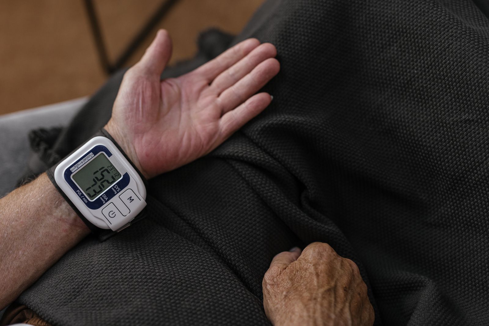 An older person checking their blood pressure at home